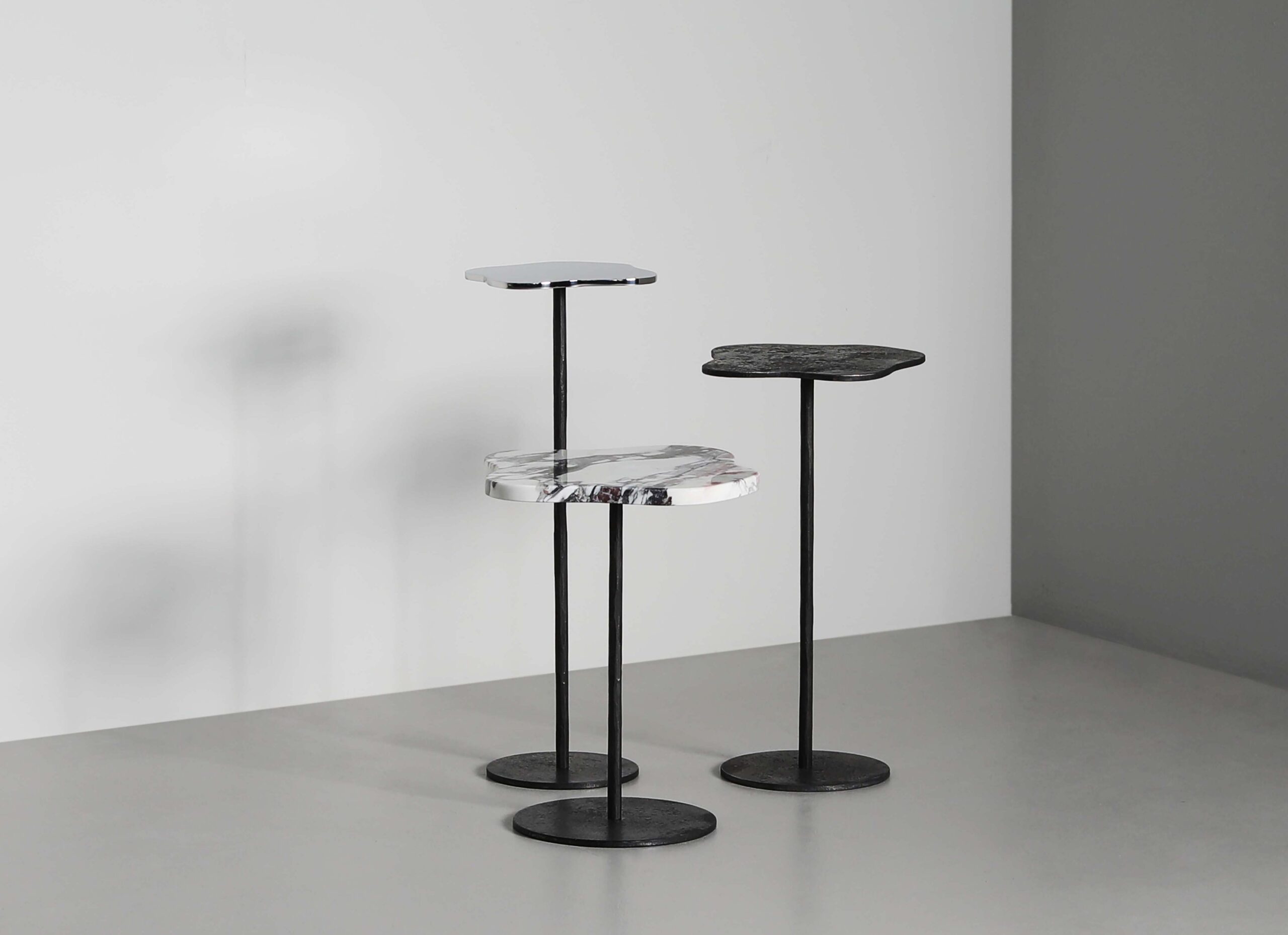 Lily cocktail tables with tops of Moon, Breccia marble, and polished stainless steel + Moon stems and bases