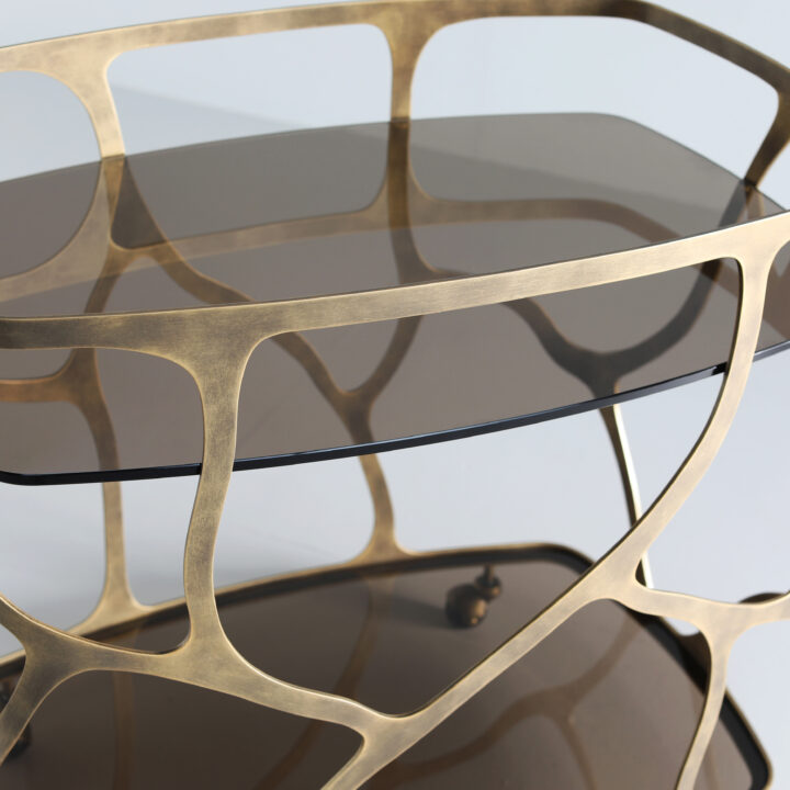 Finished in Florentine Gold with a smoked glass top and shelf