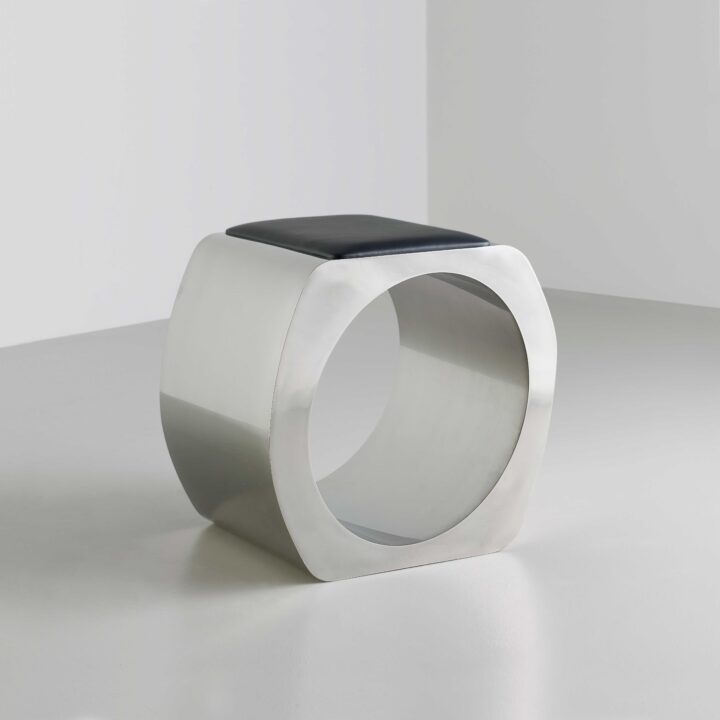 Made in stainless steel with a satin polish and upholstered in black leather